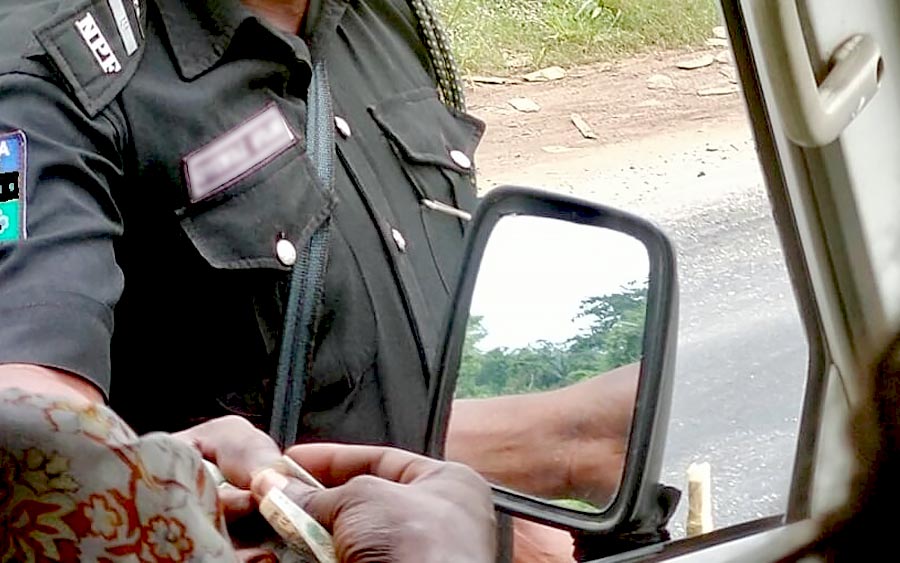 A Nigerian Police Officer openly collecting bribe from a motorist 